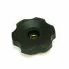 The Fiorenzato A1600004 Steam Knob is a black, round plastic knob with a scalloped edge and a central square brass insert, shown on a white background. © 2025 1st-line.com