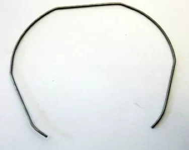 The Grimac GR766 Filter Retaining Spring for Zola & MiniGrimac is a thin, bent metal wire shaped into an open, uneven octagon with slightly curved ends, displayed against a plain white background. © 2025 1st-line.com