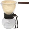 The Hario 240ml Woodneck Coffee Dripper features a glass pot, wooden handle, cloth filter in a metal strainer, and a leather strap around the neck. © 2025 1st-line.com