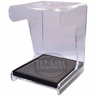 The Hario V60 Acrylic Coffee Dripper Stand w/ Drip Tray holds your V60 or other drippers above a cup or carafe for manual brewing, featuring a clear acrylic frame, black perforated metal base, and built-in drip tray. © 2025 1st-line.com