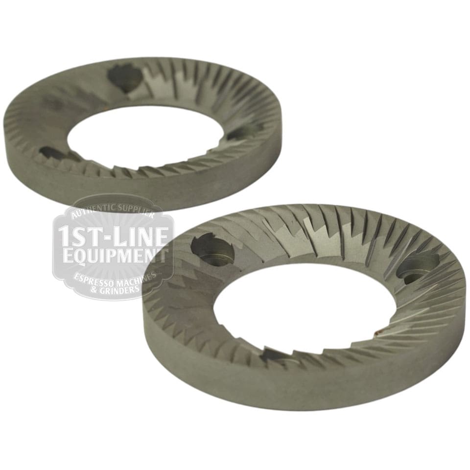 The image shows a set of two Mazzer FMA00182D/QQQ 1-phase 58mm flat grinding burrs with sharp angled teeth and bolt holes for coffee grinding, featuring a semi-transparent 1st-Line Equipment watermark. © 2025 1st-line.com