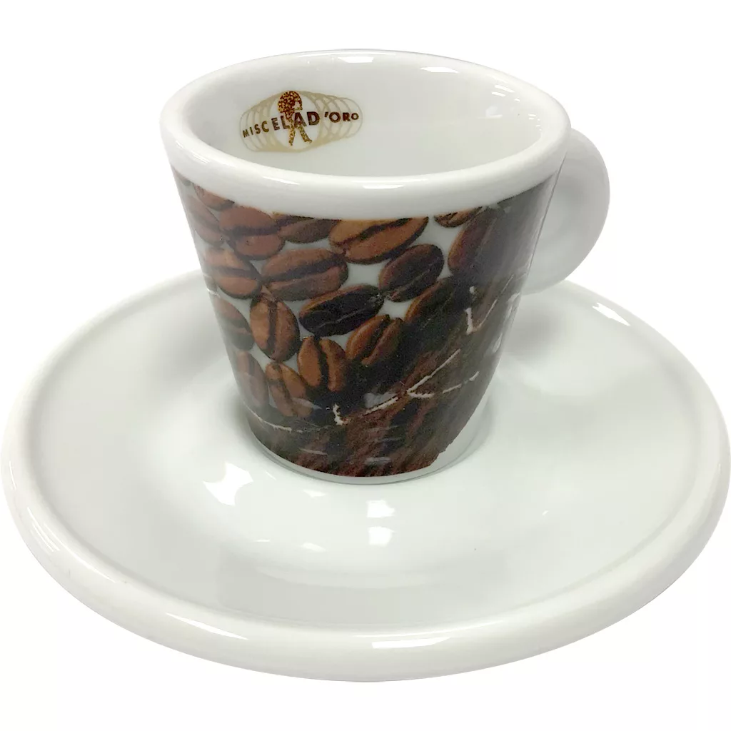 The Miscela dOro Espresso Cup & Saucer - 2 fl oz features coffee bean designs and a logo inside the white cup, creating an elegant touch for your espresso moments. © 2025 1st-line.com