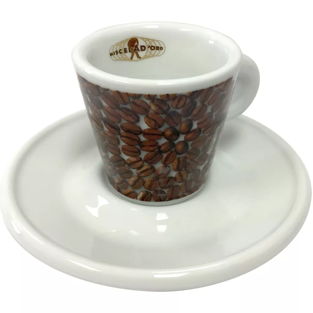 The Miscela dOro Espresso Cup & Saucer - 2 fl oz is a white ceramic set with coffee bean accents and Miscela dOro in gold on the inner rim, offering a classic and elegant way to enjoy your espresso. © 2025 1st-line.com