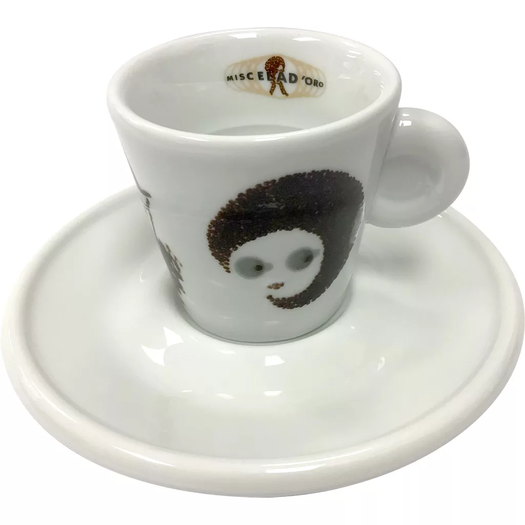 The Miscela dOro Espresso Cup & Saucer (2 fl oz) is white with a brown, cartoon-style face and large eyes, plus Miscela D’Oro in gold lettering on the inside rim. Includes a matching saucer. © 2025 1st-line.com