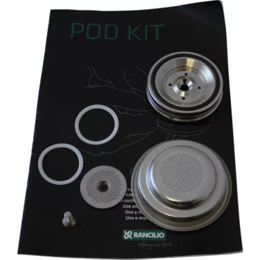 The Rancilio 10-705-403 E.S.E. Conversion Pod Kit - Silvia, Epoca 1G includes metal filter parts, gaskets, and a small screw shown on a black instruction manual. © 2025 1st-line.com