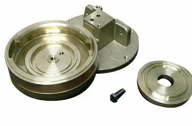 The Rancilio 10705400 Pod Adaptable Grouphead Body set includes a machined grouphead body, large circular component, small disk, mounting bracket, and screw—all pod adaptable and displayed on a white background. © 2025 1st-line.com