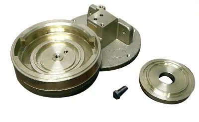 The Rancilio 10705400 Pod Adaptable Grouphead Body set includes a machined grouphead body, large circular component, small disk, mounting bracket, and screw—all pod adaptable and displayed on a white background. © 2025 1st-line.com