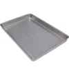 The Rancilio 32330365 Drip Tray is a rectangular, silver metal tray with slightly raised edges and a flat surface featuring a subtle embossed center design; shown empty and viewed at an angle. © 2025 1st-line.com