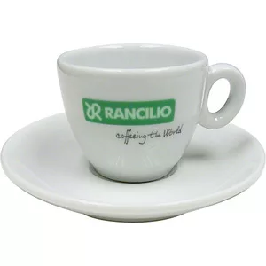 The Rancilio Espresso Cup & Saucer set includes a white cup with handle and matching saucer. The cup features a green RANCILIO logo and cofféing the World in black beneath the logo. © 2025 1st-line.com