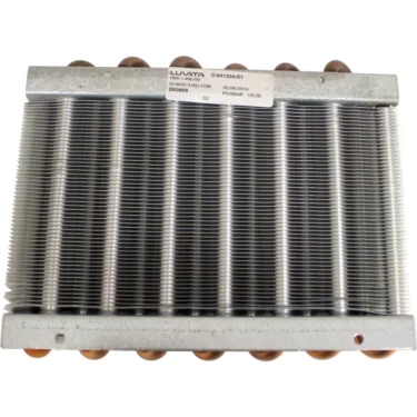 The SPM 02.NI0013.001 Condenser for Nina is a metal heat exchanger coil with copper tubes and parallel aluminum fins, featuring a label on top with manufacturer and product information. © 2025 1st-line.com