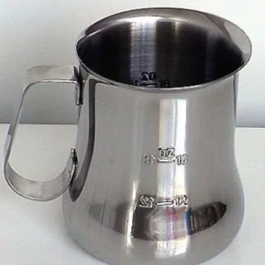 The Update International 24 fl oz (70 cl) Measuring Milk Frothing Pitcher with a handle and engraved measurement markings is displayed on a white surface with a white background. © 2025 1st-line.com