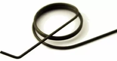 A close-up of the Mazzer S000MOB03 Doser Spring for SuperJolly, featuring a circular coil with two straight arms extending outward, displayed on a white background. © 2025 1st-line.com