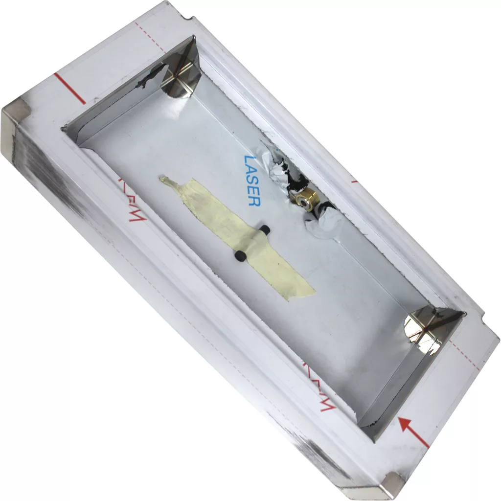 DISCONTINUED ACS VES0009 Drip Tray: Rectangular metal box with white protective cover, open top, and corner mounting brackets. Contains two circular metal parts and taped wiring. Interior marked LASER. © 2025 1st-line.com