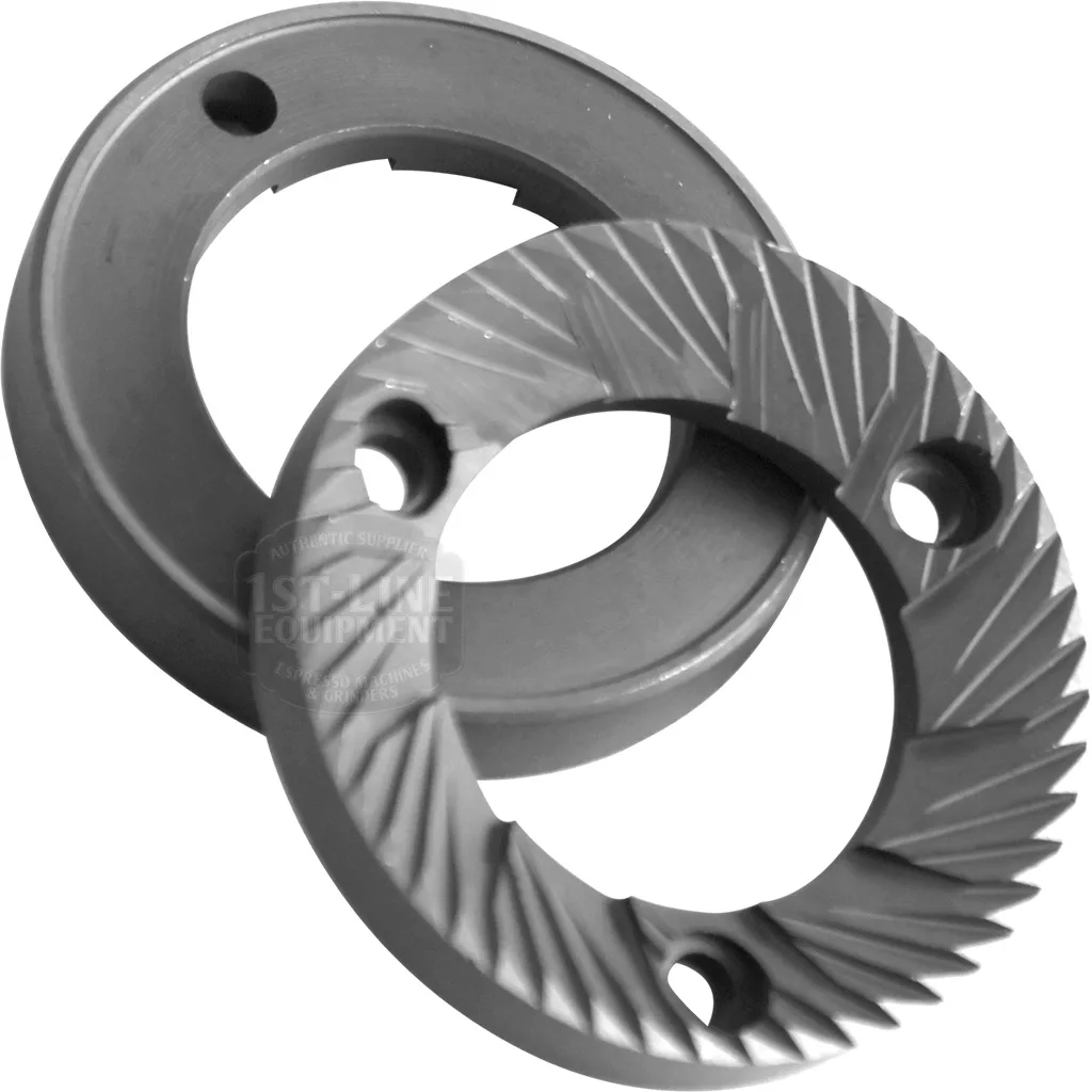 The DISCONTINUED Ascaso MC..25 49mm Flat Grinding Burrs (set of 2) are circular, metallic, and industrial, with sharp angled grooves and three mounting holes; one burr is shown flat, the other propped at an angle. © 2025 1st-line.com