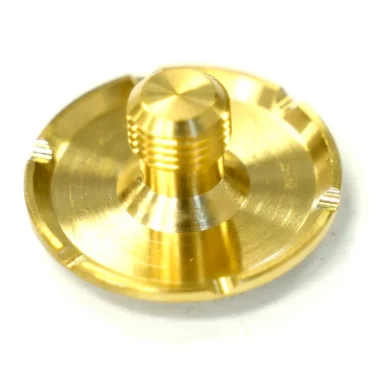 A close-up of the Bezzera 7479941 Sprayer, a round gold-colored metal component with a threaded cylindrical center and a flat base featuring four notches along its edge. © 2025 1st-line.com