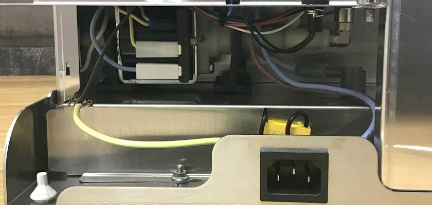 Close-up of the Lelit Elizabeth V3 Dual Boiler Espresso Machine with its casing partially open, revealing internal wiring, connectors, power input socket, and cables connected to the machine’s components. © 2025 1st-line.com