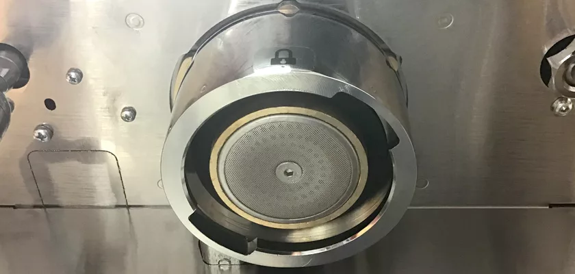 Close-up view of a metallic circular part in a machine, showing a fine mesh filter and shiny metal—likely the portafilter or group head of the Lelit Elizabeth V3 Dual Boiler Espresso Machine. © 2025 1st-line.com