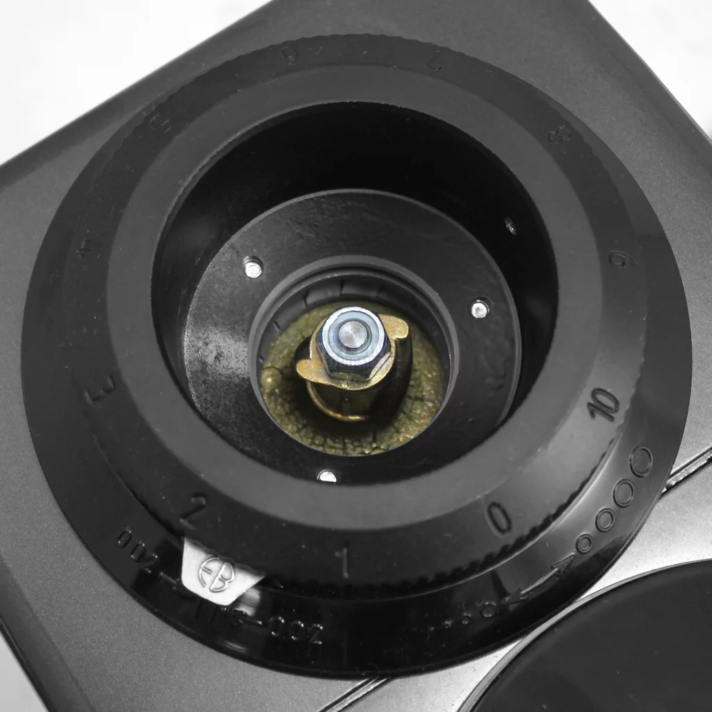 Close-up of the 1st-line Michael Espresso Coffee Grinders grind size adjustment dial, marked 0–10 around a central metal burr and bolt, with a black plastic ring encircling the shiny metal components. © 2025 1st-line.com