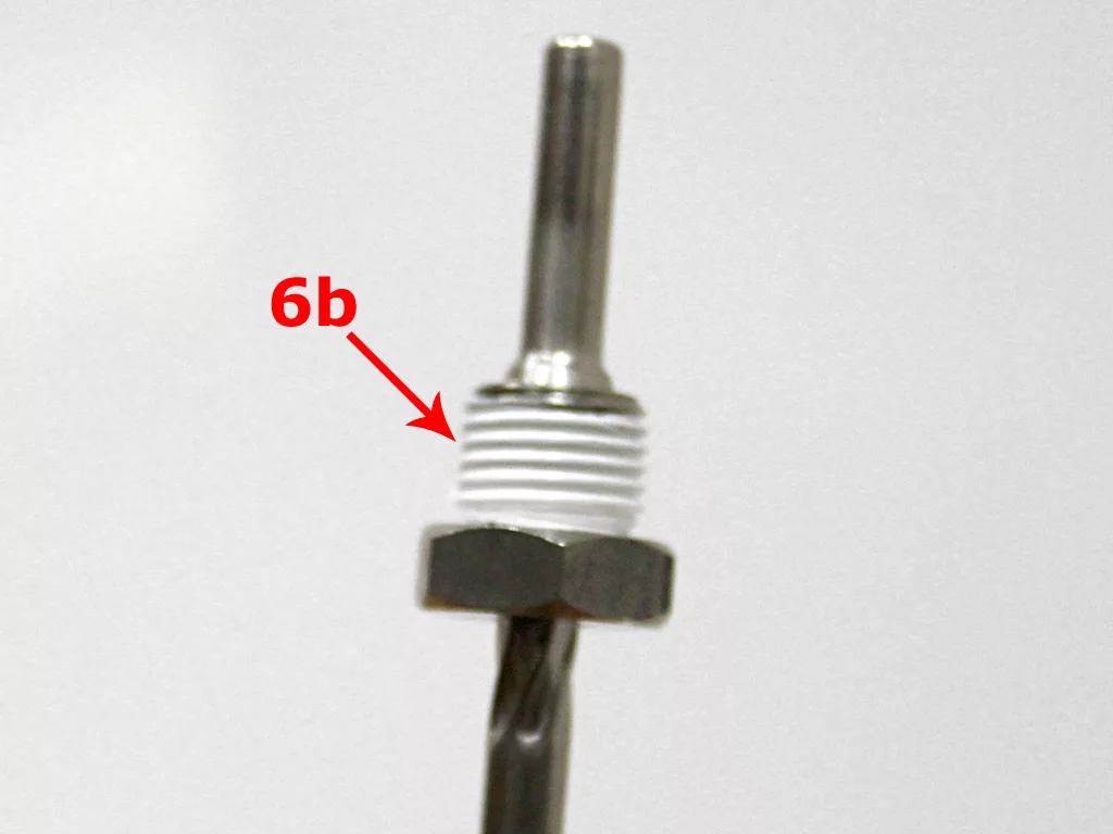 A metal rod from a VBM Dual Boiler espresso machine with a threaded section wrapped in white material, labeled “6b” with a red arrow pointing to the threads, and a hexagonal nut below—part of the 3.5 to 4.0 conversion process. © 2025 1st-line.com