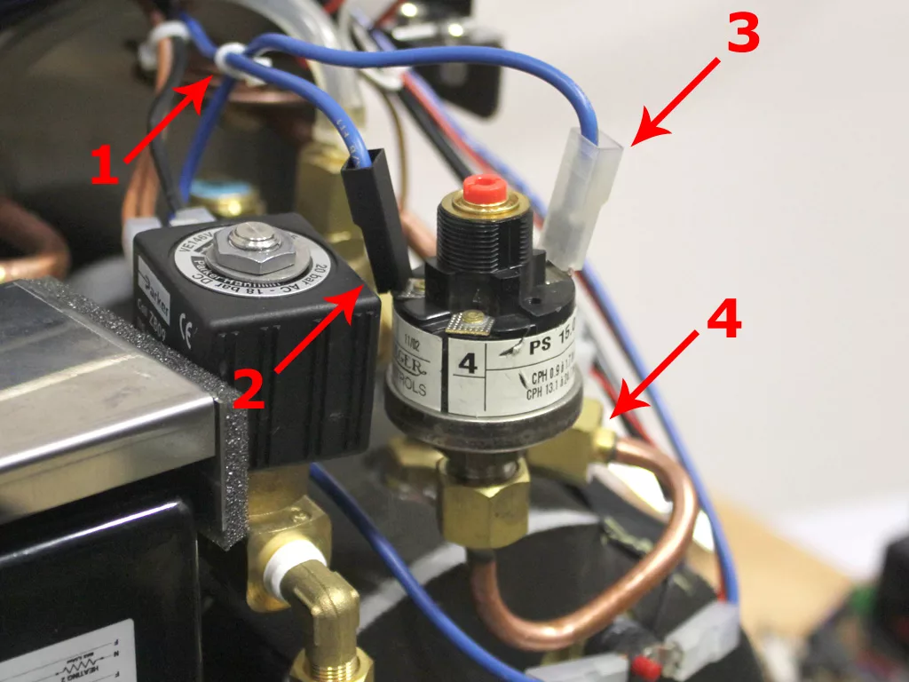 Close-up of a VBM Dual Boiler espresso machine’s internal components with four arrows pointing to labeled parts: 1. blue wire, 2. black solenoid valve, 3. white wire connector, 4. pressure switch with labels and attached wires. © 2025 1st-line.com