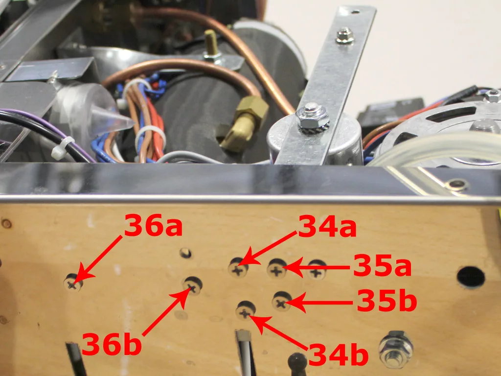 Close-up of a VBM Dual Boiler’s internal components with a wooden panel. Red arrows and labels (34a, 34b, 35a, 35b, 36a, 36b) identify screws for the 3.5 to 4.0 conversion. Wires and metal parts are visible behind the panel. © 2025 1st-line.com