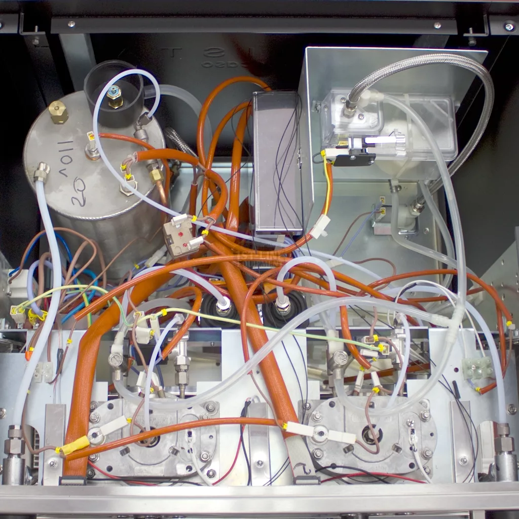 Interior view of the SOLD RETURNED AND REFURBISHED - Ascaso Bar 2 Group Espresso Machine (110V, direct connect, vibration pumps), displaying its organized internal layout with neatly arranged tubes, wires, tanks, and connectors. © 2025 1st-line.com