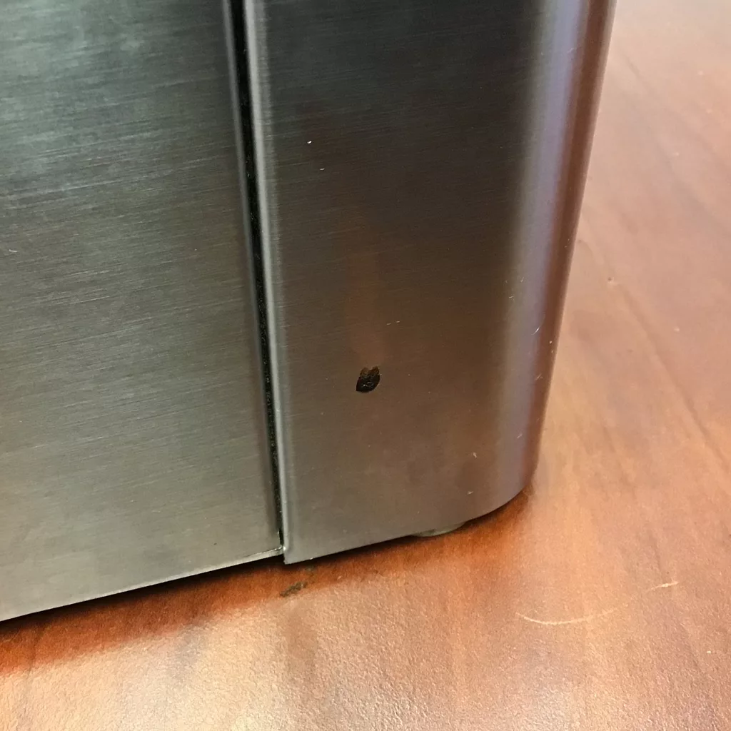A small black mark or chip is visible on the lower corner of this returned & refurbished SOLD Lelit PL71 William Espresso Coffee Grinder, placed next to a wood-patterned floor. © 2025 1st-line.com