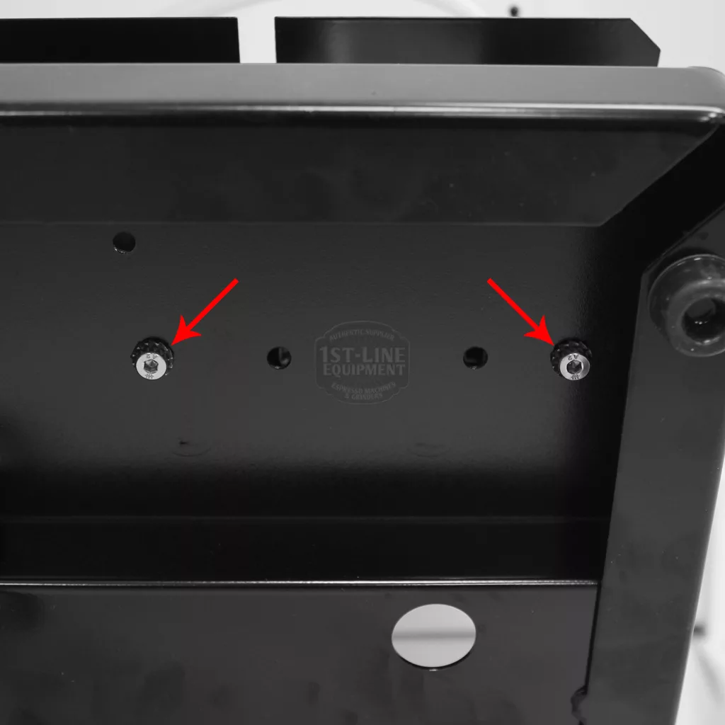 Close-up of a black metal surface with two screws, each marked by a red arrow for accessing the inside of the Rancilio Silvia. In the background, a faint, circular logo reads 1st-Line Equipment. © 2025 1st-line.com