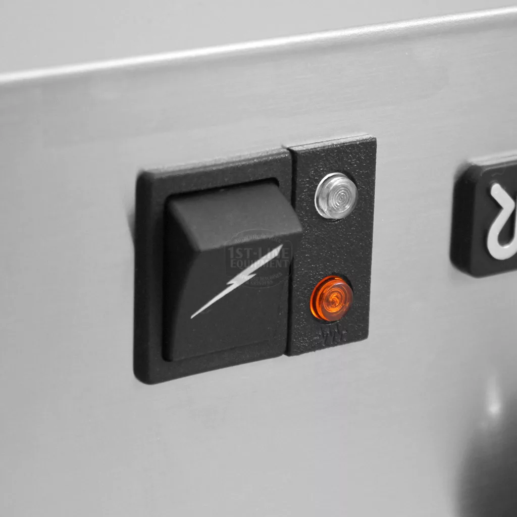 Close-up of a black rocker switch next to a small silver button and an orange indicator light on the metallic surface of a Rancilio Silvia espresso machine. © 2025 1st-line.com