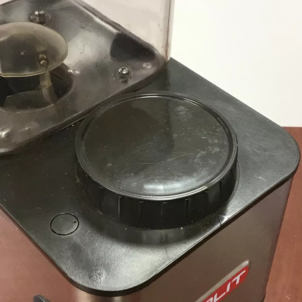 Close-up of a SOLD Lelit PL71 William Espresso Coffee Grinder (returned & refurbished), black with a transparent lid, large round adjustment dial, and small top button, sitting on a wooden table. © 2025 1st-line.com