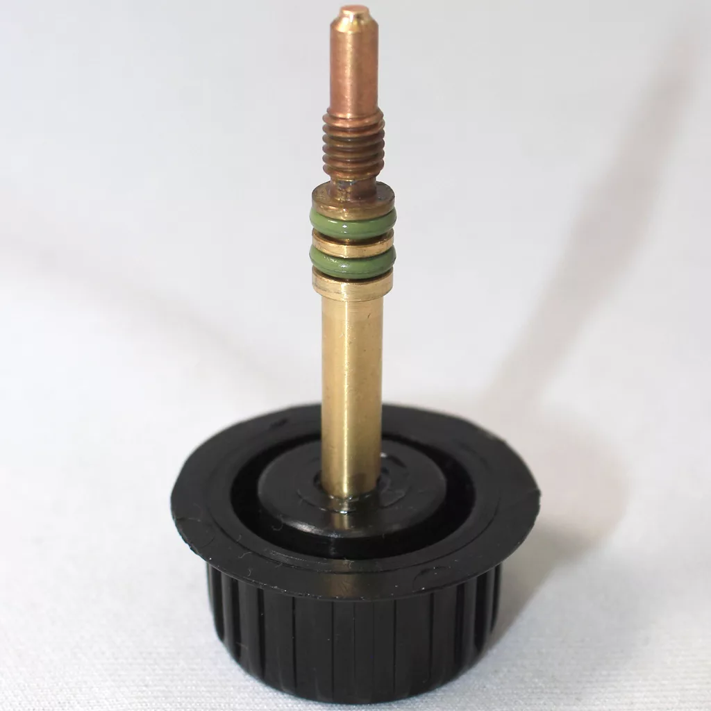 A close-up of a Lelit brass valve stem with rubber O-rings, mounted on a circular black plastic base, photographed against a plain, light-colored background—ideal for use on the Support Page or in Technical Support documentation. © 2025 1st-line.com