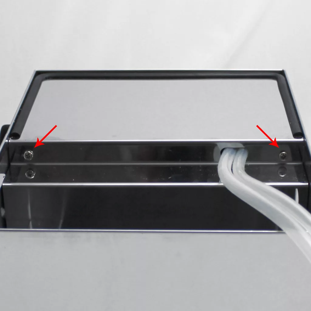 A close-up of a metallic device, likely part of an espresso machine such as the Lelit PL41TEM Anna, with two red arrows pointing to screws on each side. Two white cables exit on the right against a plain light background. © 2025 1st-line.com