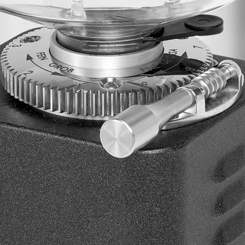 Close-up of a metal adjustment knob and gear on the ECM S-Automatik 64 Espresso Grinder, featuring engraved numbers. The textured handle and precise components indicate its designed for fine-tuning espresso grind settings. © 2025 1st-line.com