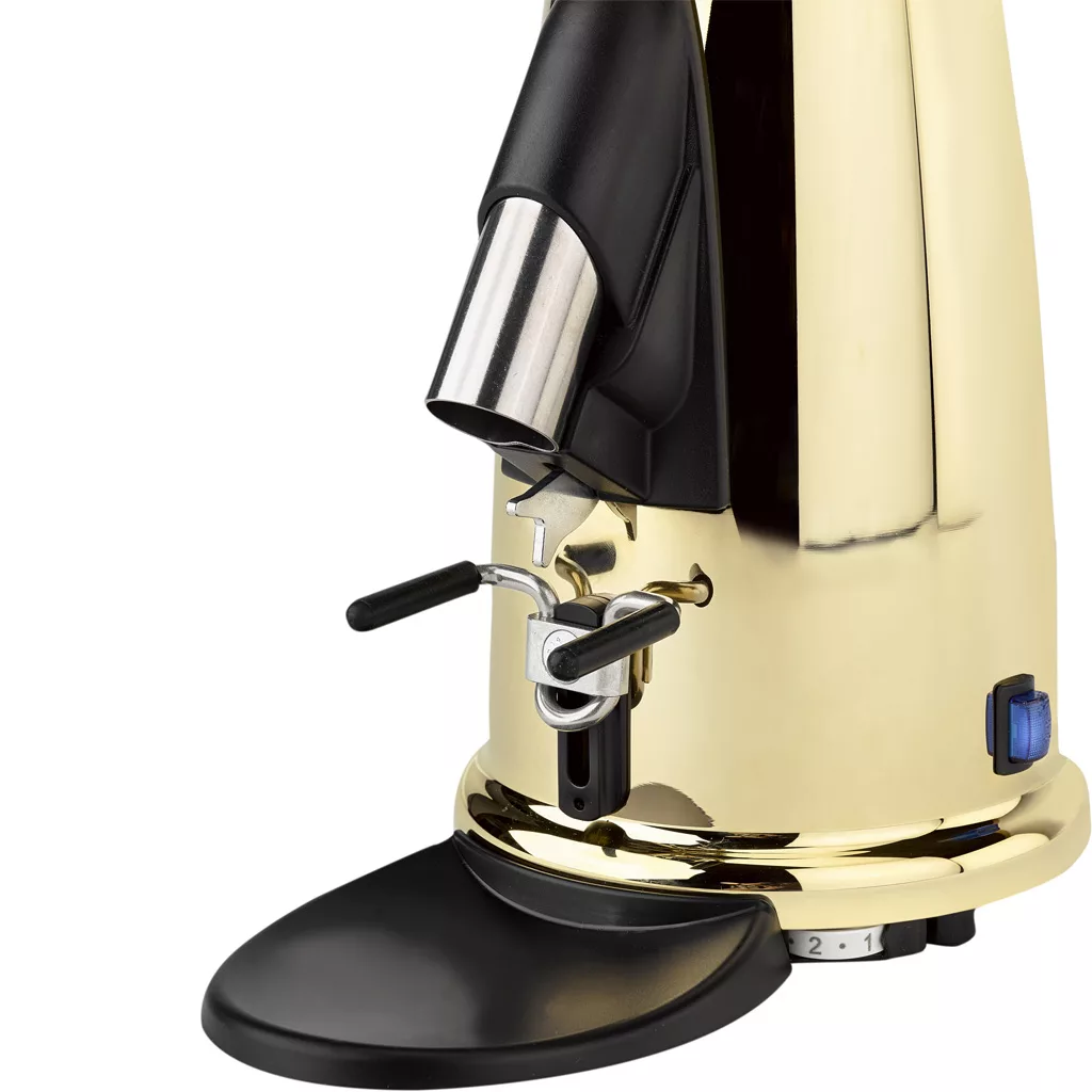 A close-up of a shiny gold Elektra MSD Espresso Coffee Grinder with a black hopper, two adjustment levers, and a stainless steel grounds tray. A blue power switch is visible on the lower right side of the grinder’s base. © 2025 1st-line.com