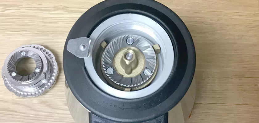 Close-up of DISCONTINUED 1st-line Sonny Espresso Coffee Grinder burr set on wood: one burr installed in the grinder, the other beside it. © 2025 1st-line.com