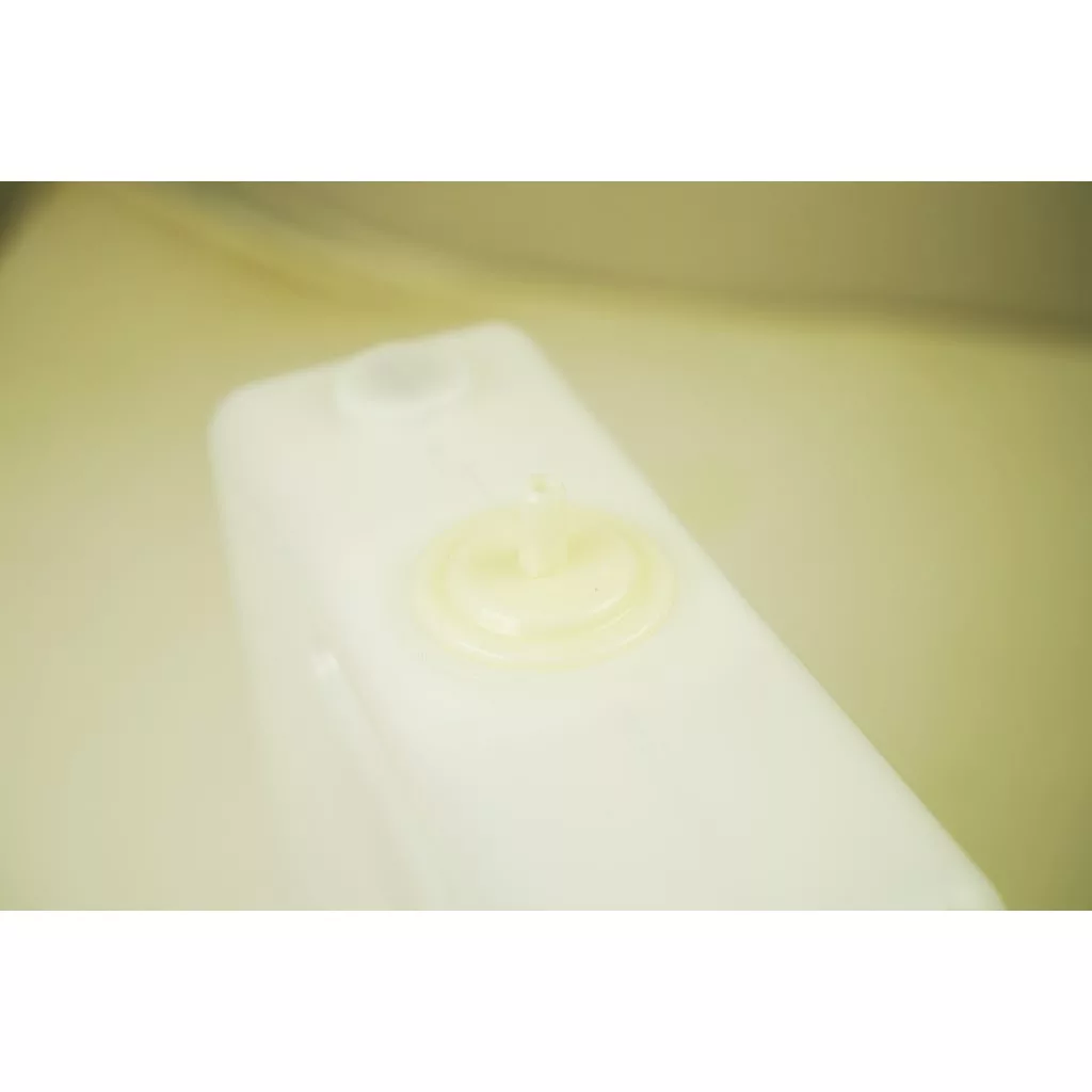 A close-up of a white plastic container with a circular cap and nozzle, designed for the Lelit MC747Plus In Tank Water Softener / Particle Filter (70 L), set against a blurred, light-colored background. © 2025 1st-line.com