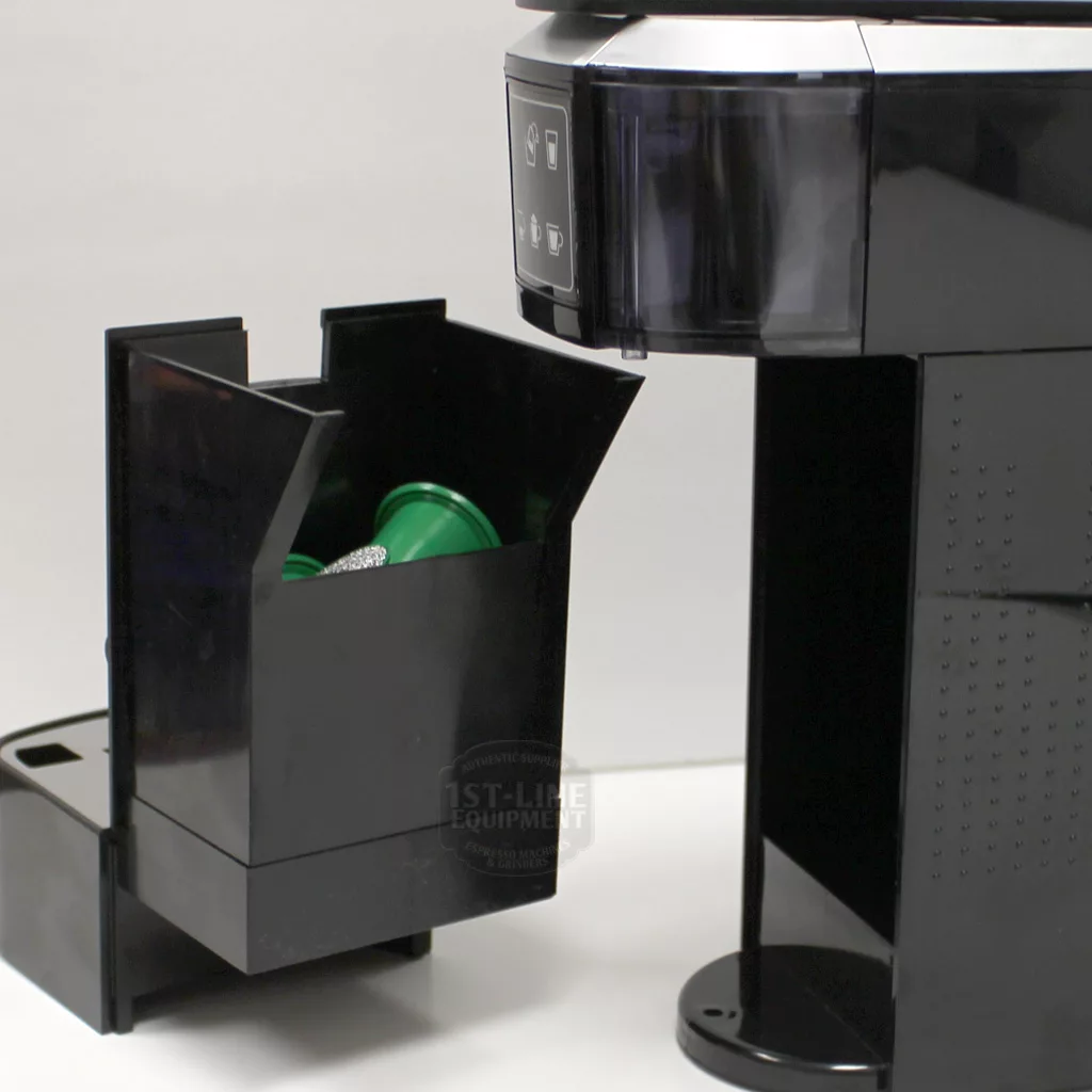 A close-up of the (SOLD) SIDEWALK SALE - Caffeum Perfectus slimNESs Espresso Machine F306, showing its removable bin with used coffee pods—some with green lids—next to the F306 on a white background. © 2025 1st-line.com