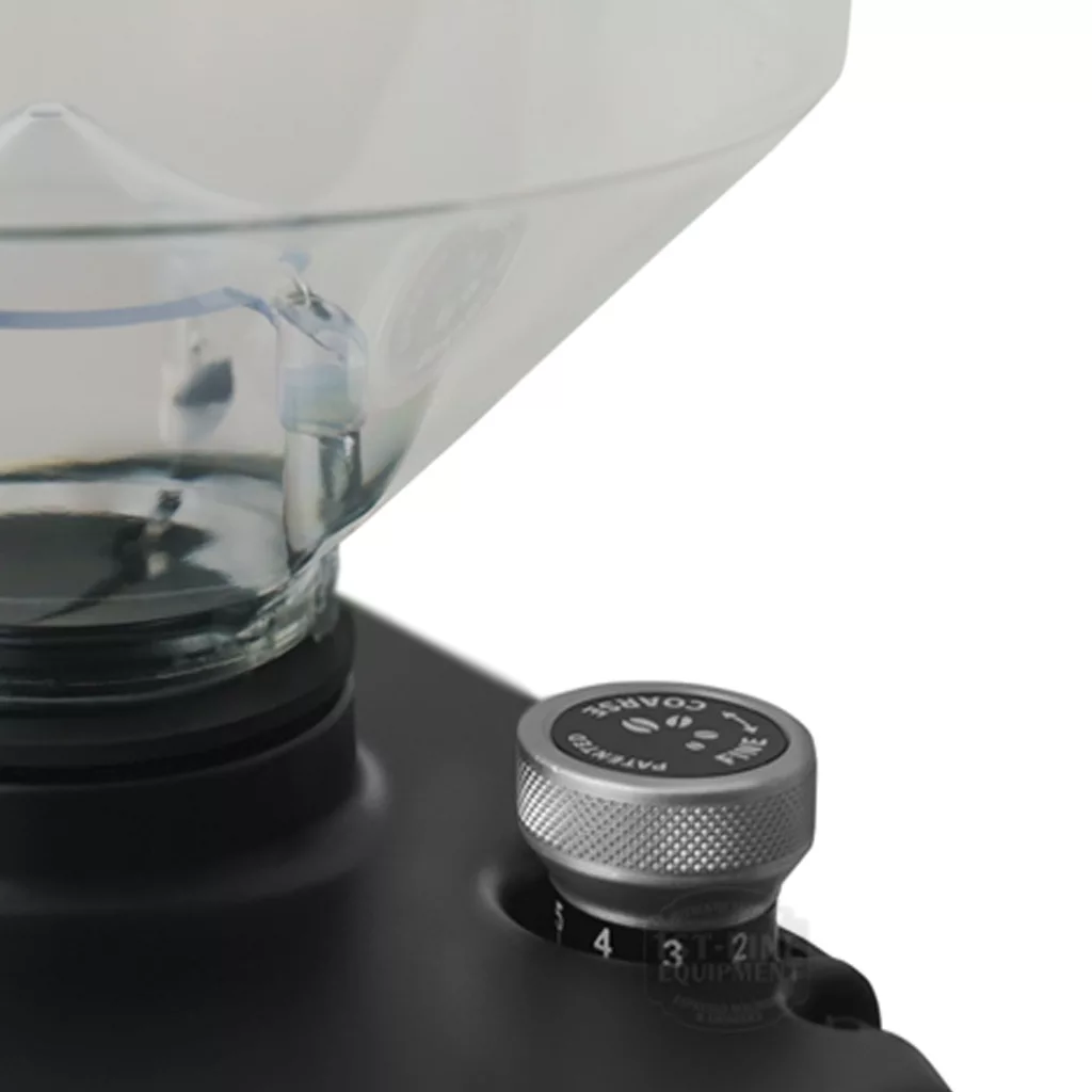Close-up of the DISCONTINUED Eureka Atom Specialty 65 Espresso Coffee Grinder w/ Short Bean Hopper, showing the bottom of the transparent hopper and a textured metal dial marked Patented with grind size numbers 1 to 4. © 2025 1st-line.com