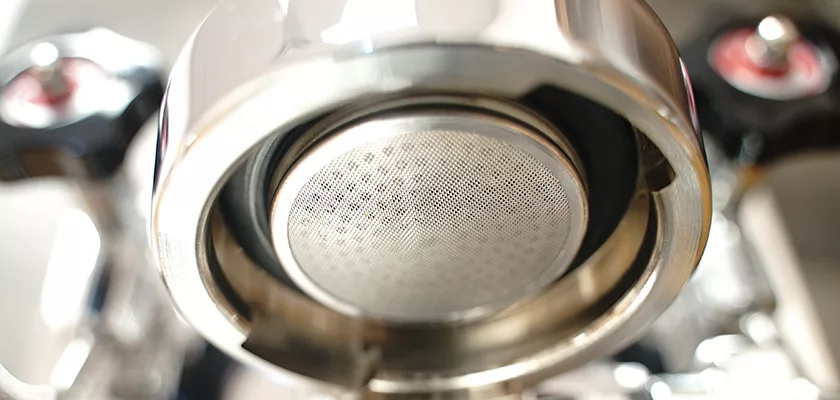 Close-up of the portafilter and metal filter basket on the DISCONTINUED ECM Mechanika V Slim Espresso Machine, highlighting the fine mesh used for brewing coffee grounds. © 2025 1st-line.com