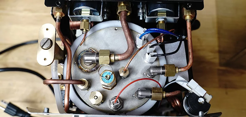 Top-down view of the internal components of the DISCONTINUED ECM Mechanika V Slim Espresso Machine, featuring copper tubes, electrical wires, connectors, and fittings attached to the cylindrical metal boiler. © 2025 1st-line.com