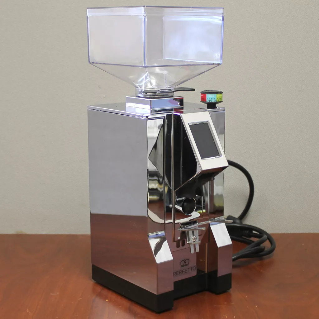 A refurbished SOLD Eureka Mignon Perfetto Stepless Doserless Espresso Coffee Grinder with a digital display, front control buttons, and transparent hopper sits on wood; a power cord extends from the back. © 2025 1st-line.com