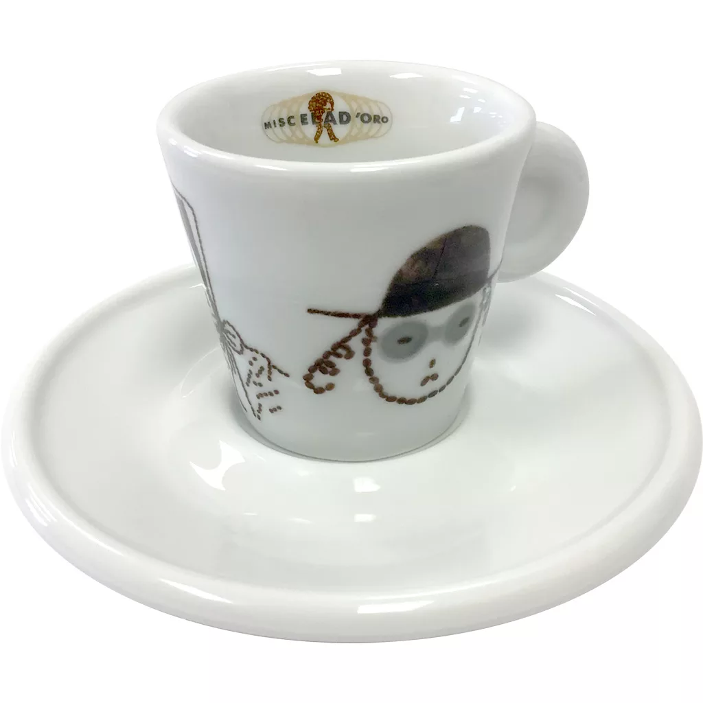 A white espresso cup with a handle, decorated with a simple illustration of a face with glasses and a hat, sits on a matching saucer. The inner rim features the words Miscela dOro in gold. © 2025 1st-line.com