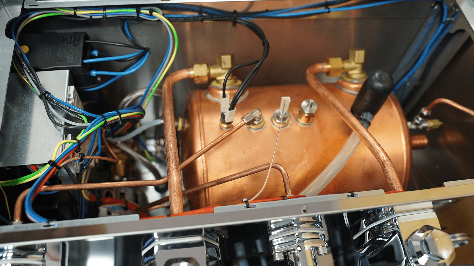 Close-up view of the internal components of the DISCONTINUED Lelit PL2SVH2 Giulietta Espresso Machine for Commercial Use (2 Group, 220v), showing copper boiler, wires, metal pipes, and connectors inside the sturdy metal casing. © 2025 1st-line.com