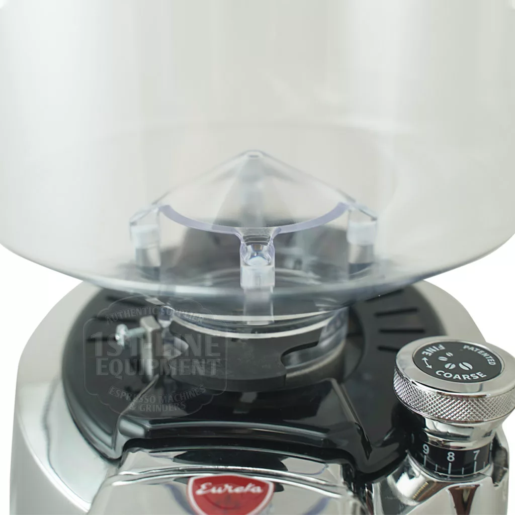 Close-up of the discontinued Eureka Zenith 65 E Espresso Coffee Grinder with steel burrs, a tall transparent bean hopper, grind size adjustment from coarse to fine, and the Eureka logo on front. © 2025 1st-line.com