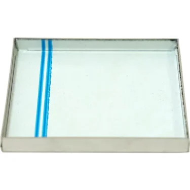 The Lelit MC305 Grinds Catch Tray is a rectangular glass plate with a metal frame and a single blue vertical line near the left edge, designed as an accessory for Lelit coffee machines. © 2025 1st-line.com