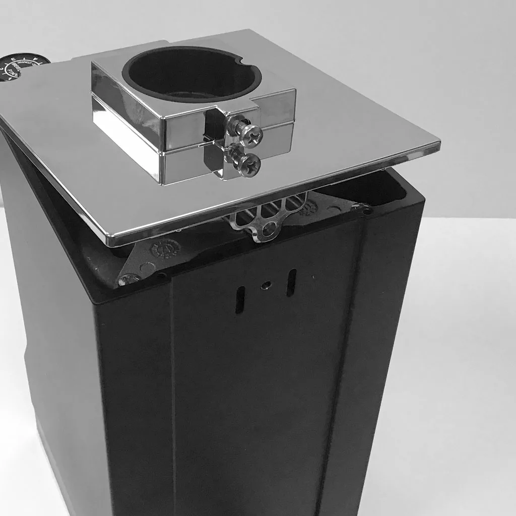 A black and chrome metal electrical junction box with a rectangular cover and circular clamp, this piece evokes the sleek design of an Eureka Mignon Grinder, shown against a plain light background. © 2025 1st-line.com