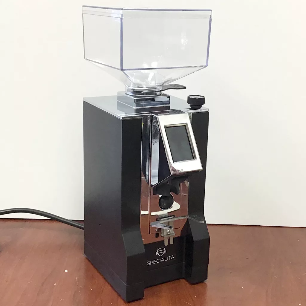 A SOLD Eureka Mignon Specialita Stepless Doserless Espresso Coffee Grinder (returned & refurbished) with a black and silver finish, clear bean hopper, and digital display sits on a wooden surface against a plain white background. © 2025 1st-line.com