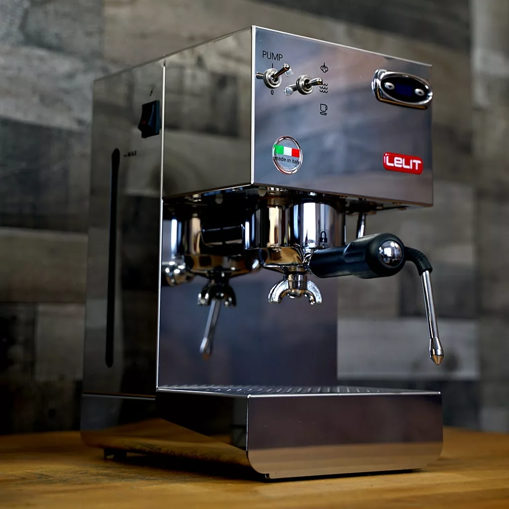 A (SOLD) SIDEWALK SALE - Lelit PL41PLUST Glenda PID Espresso Machine OPEN BOX sits on a wooden countertop, showcasing dual switches, portafilter, steam wand, and an Italian flag sticker against a modern tiled backsplash. © 2025 1st-line.com