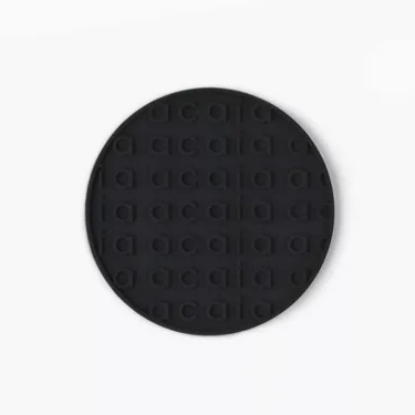 The Acaia AA024AC Heat Resistant Coaster for Pearl Model S in black features a round silicone design with Acaia embossed in a grid pattern, shown on a plain white background; ideal for use with the Pearl Model S. © 2025 1st-line.com