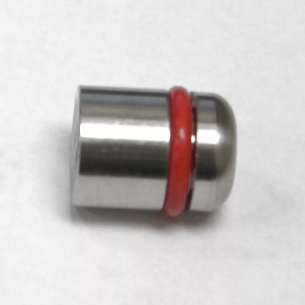 A small, cylindrical metal water tank adapter with a rounded end and a red rubber ring near one side, placed on a white surface—perfect for installing ECM Switchable models. © 2025 1st-line.com